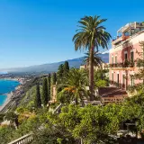 Vue panoramique d'un hôtel en Italie du Sud, bord de mer, avec des palmiers et une vue sur la côte.