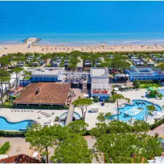 Vue aérienne d'un camping et d'une plage à Cavallino, Italie. Piscines, mobil-homes et mer bleue.