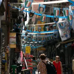 Rue animée de Naples, décorée de drapeaux du Napoli. Malgré l'ambiance festive, on sent le côté parfois dangereux de cette ville vibrante.
