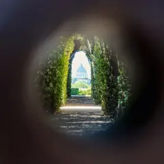 Un chemin bordé de verdure mène à la coupole de Saint-Pierre, une vision de Rome insolite et secrète à travers un trou de serrure.