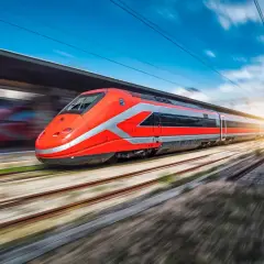 Train rouge vif filant sur les rails, prêt pour un voyage rapide entre Rome et Naples.