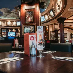 Table dressée au Hard Rock Café Rome, avec un verre souvenir "Hurricane" et des menus. Le plafond est orné d'anges.