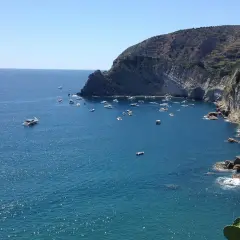 Baie de Sant'Angelo à Ischia, parsemée de bateaux sous un ciel bleu éclatant.