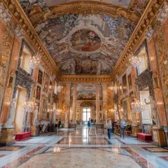 Intérieur somptueux du palais Colonna, avec fresques au plafond, statues, lustres en cristal et marbre au sol.