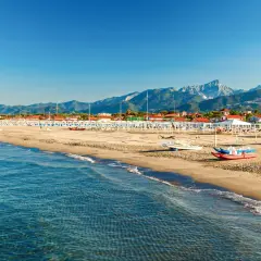 Plage de sable fin, mer bleue et montagnes en arrière-plan. Idéal pour savoir où aller en Toscane bord de mer.
