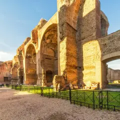Vestiges impressionnants du **bain de Caracalla** à Rome, avec ses arches massives en briques et pierre, baignées par le soleil.