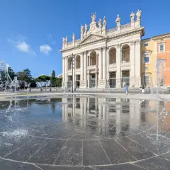 La fontaine devant la cathédrale de Rome, Saint-Jean-de-Latran, reflète le ciel bleu et l'architecture imposante.