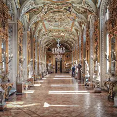 Le **Palazzo Doria Pamphilj**, un corridor orné de statues et de fresques, baigné de lumière.