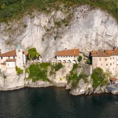 Ensemble de bâtiments accrochés à une falaise surplombant un lac, près de Baveno, Italie.