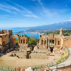 Magnifique **aréne en Italie** avec vue sur la mer et l'Etna. Vestiges antiques sous un ciel bleu éclatant.