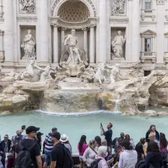 La fontaine de Trevi, avec ses statues majestueuses et ses chevaux marins, attire une foule de visiteurs capturant ce moment magique avec leurs téléphones.