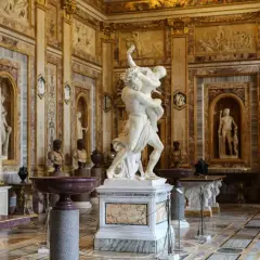 Salle somptueuse de la **Gallerie Borghese** ornée de sculptures antiques, dont le groupe du Bernin, et de riches décorations murales.