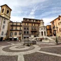 Place de la ville avec une fontaine monumentale et des bâtiments colorés. Un endroit idéal pour se détendre et acqui terme.