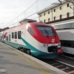 Le train Leonardo Express, reliant Fiumicino à Termini, est à quai. Des voyageurs attendent sur le quai pavé.