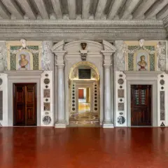 Intérieur du Palazzo Grimani, avec ses portes en bois sombres, ses bustes en marbre et ses décorations murales élaborées.