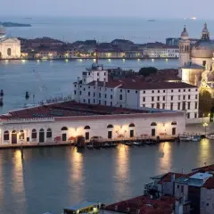 Vue de Venise au crépuscule, avec la basilique Santa Maria della Salute et le bâtiment de la Fondation Pinault Venise illuminés.