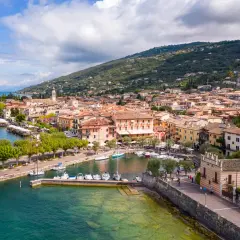 Vue aérienne de Torri del Benaco, un charmant village italien au bord du lac de Garde, avec ses maisons colorées, son port animé et ses collines verdoyantes.