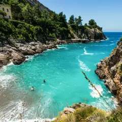 Baignade dans les eaux turquoise d'une crique isolée, un rêve de vacances sur la côte amalfitaine.