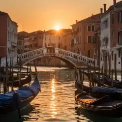 Gondoles amarrées sur un canal vénitien au coucher du soleil, avec un pont en arrière-plan.