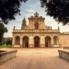 Magnifique église à Castelfiorentino, avec une façade ornée d'arches et de statues, sous un ciel doux.