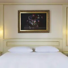 Chambre élégante d'un hôtel à Ghiffa sur le Lac Majeur, avec un tableau de fleurs au-dessus du lit.