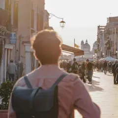 Promenade animée à Venise, près du Campo dei Mori, au coucher du soleil. Des passants flânent le long des bâtiments colorés.