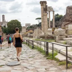 Une femme se promène sur une voie pavée dans le Forum romain, un site idéal pour visiter Rome en 4 jours.