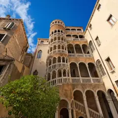 Le célèbre escalier en colimaçon du Bovolo à Venise, une merveille architecturale médiévale, se dresse fièrement sous un ciel bleu éclatant.