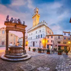 Place du peuple à Montepulciano, Toscane, avec sa fontaine ornée de lions et son hôtel de ville imposant.