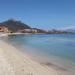 Plage de sable fin, eaux turquoise et montagnes en arrière-plan. Un rêve d'aranci in Sardegna.