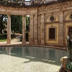 Fontaine sculptée d'un dragon à Montecatini, avec une arcade de colonnes en arrière-plan et un bassin d'eau claire.