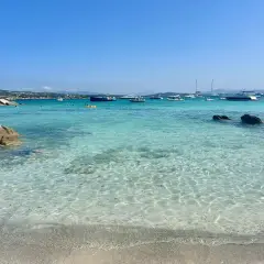 Plage de rêve en Sardaigne, eaux turquoise cristallines, rochers, bateaux au mouillage. Un coin de paradis pour savourer la ciaccia sarde.
