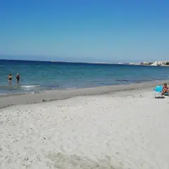 Plage de Mazara del Vallo, Italie. Des baigneurs profitent de la mer calme et du soleil sur le sable fin.