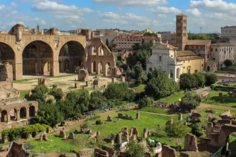 Vue panoramique du Forum Romain, idéal pour un séjour à Rome en 2 jours. Ruines antiques, églises et le Colisée en arrière-plan.
