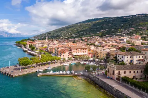 Vue aérienne de Torri del Benaco, un charmant village italien au bord du lac de Garde, avec ses maisons colorées, son port animé et ses collines verdoyantes.