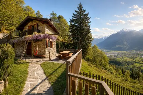 Charmante maison en pierre avec hamac et vue panoramique sur la vallée, idéale pour une location vacances Lombardie.