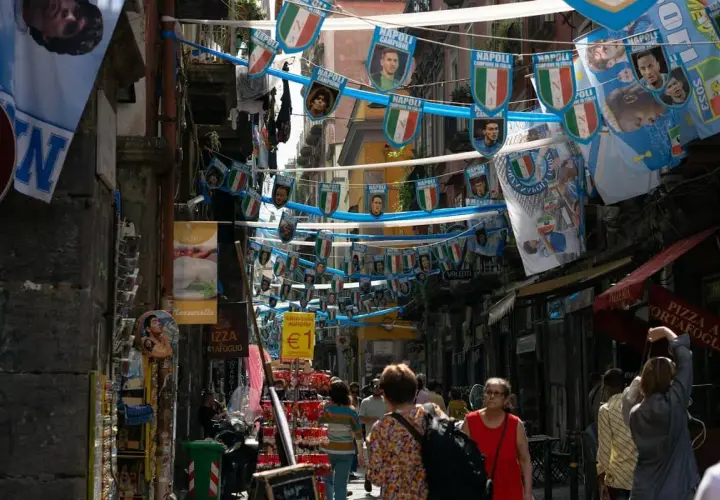 Rue animée de Naples, décorée de drapeaux du Napoli. Malgré l'ambiance festive, on sent le côté parfois dangereux de cette ville vibrante.
