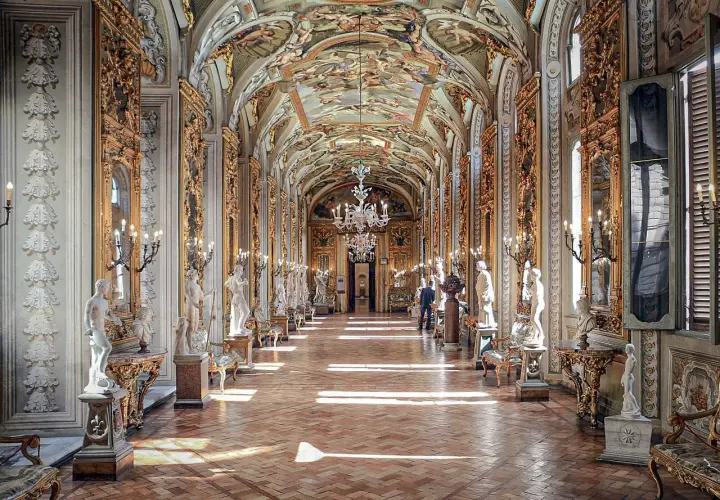 Le **Palazzo Doria Pamphilj**, un corridor orné de statues et de fresques, baigné de lumière.