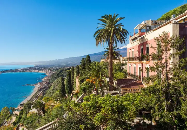 Vue panoramique d'un hôtel en Italie du Sud, bord de mer, avec des palmiers et une vue sur la côte.