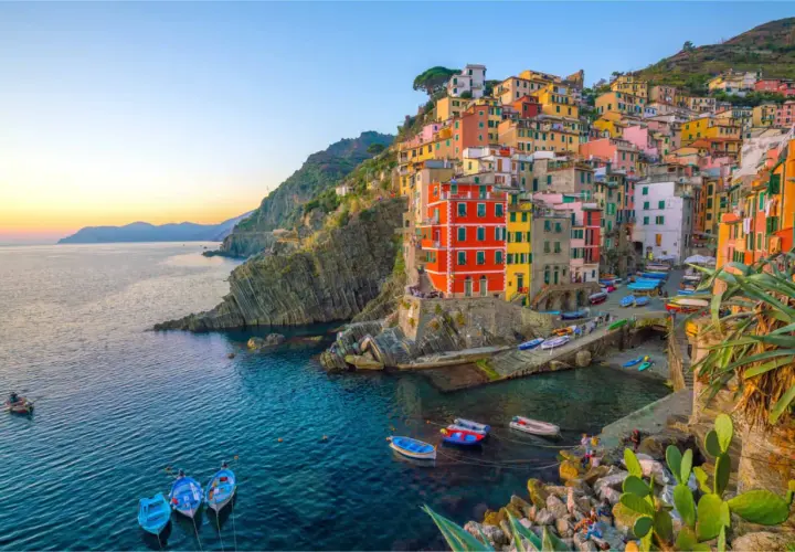 Village vacances La Spezia : maisons colorées accrochées à la falaise, bateaux dans le port, mer bleue.