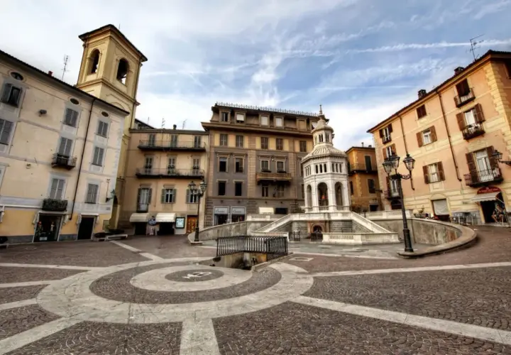 Place de la ville avec une fontaine monumentale et des bâtiments colorés. Un endroit idéal pour se détendre et acqui terme.