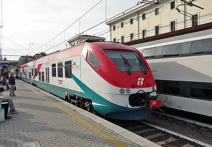 Le train Leonardo Express, reliant Fiumicino à Termini, est à quai. Des voyageurs attendent sur le quai pavé.