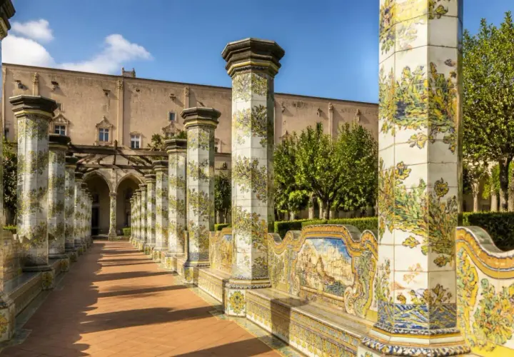 Cloître de Santa Chiara à Naples, avec ses colonnes ornées de majoliques et son banc en céramique.