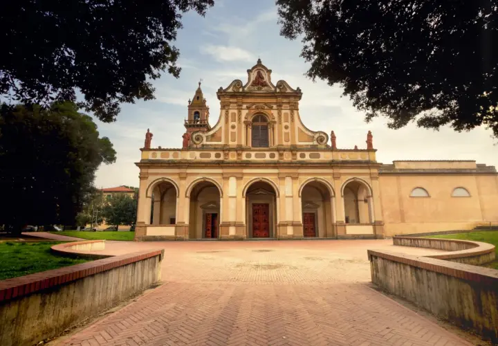 Magnifique église à Castelfiorentino, avec une façade ornée d'arches et de statues, sous un ciel doux.