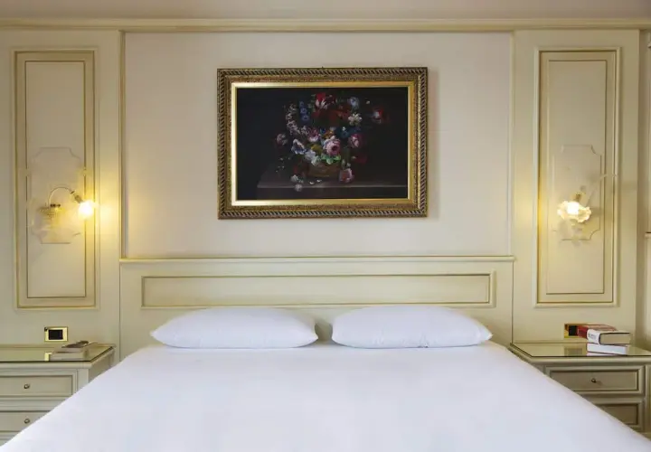 Chambre élégante d'un hôtel à Ghiffa sur le Lac Majeur, avec un tableau de fleurs au-dessus du lit.