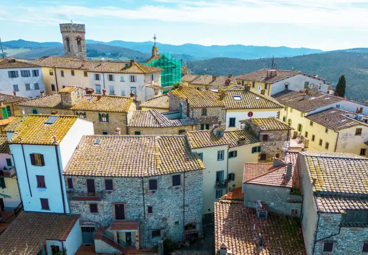 Vue aérienne d'un village toscan pittoresque, avec ses toits de tuiles ocres et ses maisons en pierre. Un paysage d'Italie authentique.