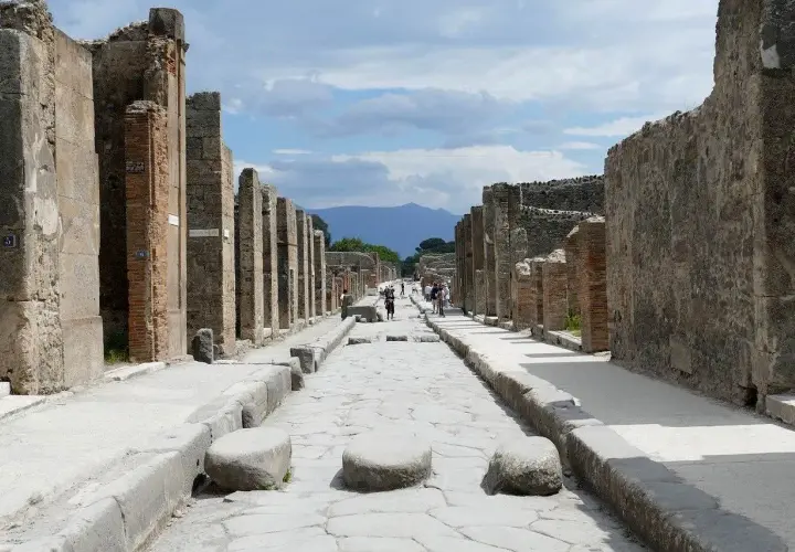 Ruines de Pompéi, une ancienne voie romaine menant vers le Vésuve. Un voyage de Rome à Pompéi est une immersion dans l'histoire.