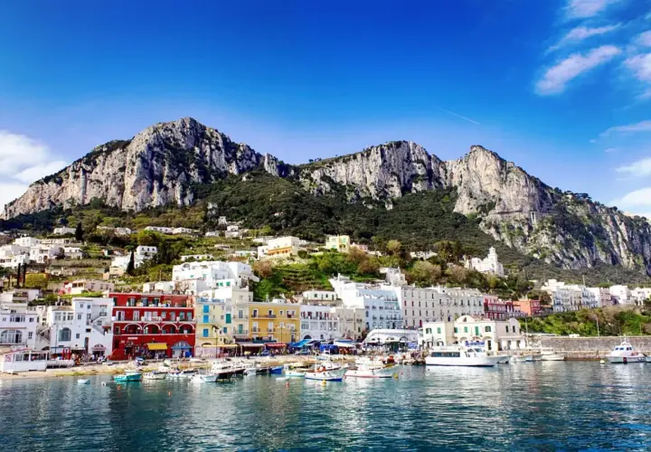 Vue du port de Capri, avec ses maisons colorées et ses montagnes escarpées. Un rêve d'évasion, loin de Rome.