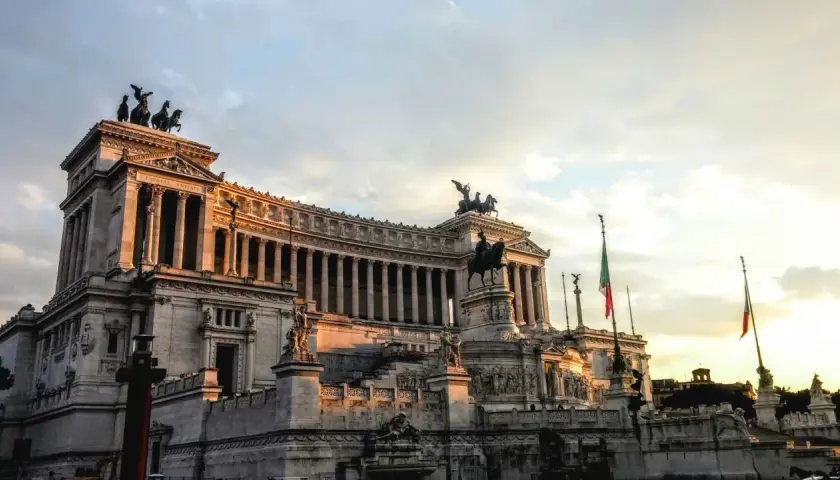 Monument imposant à Rome, idéal pour une visite avec un audioguide Rome gratuit. Le soleil couchant illumine la façade.