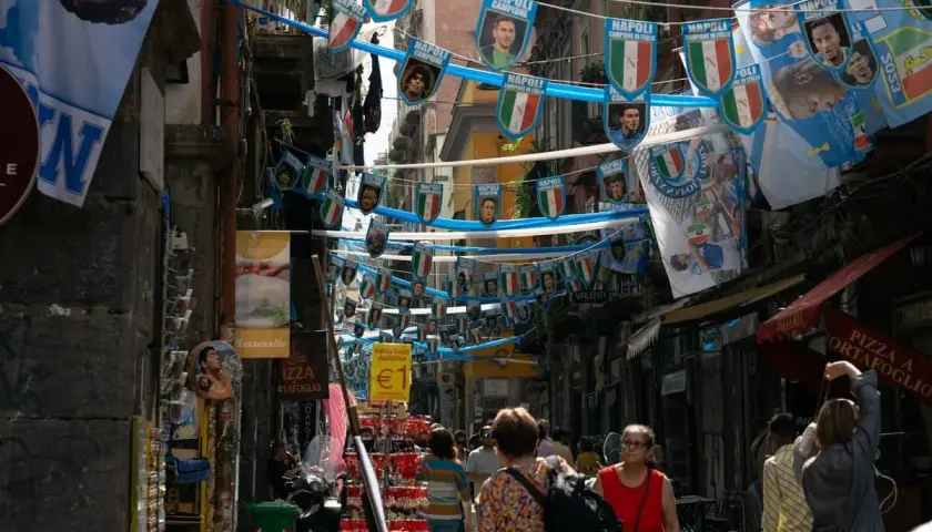 Rue animée de Naples, décorée de drapeaux du Napoli. Malgré l'ambiance festive, on sent le côté parfois dangereux de cette ville vibrante.